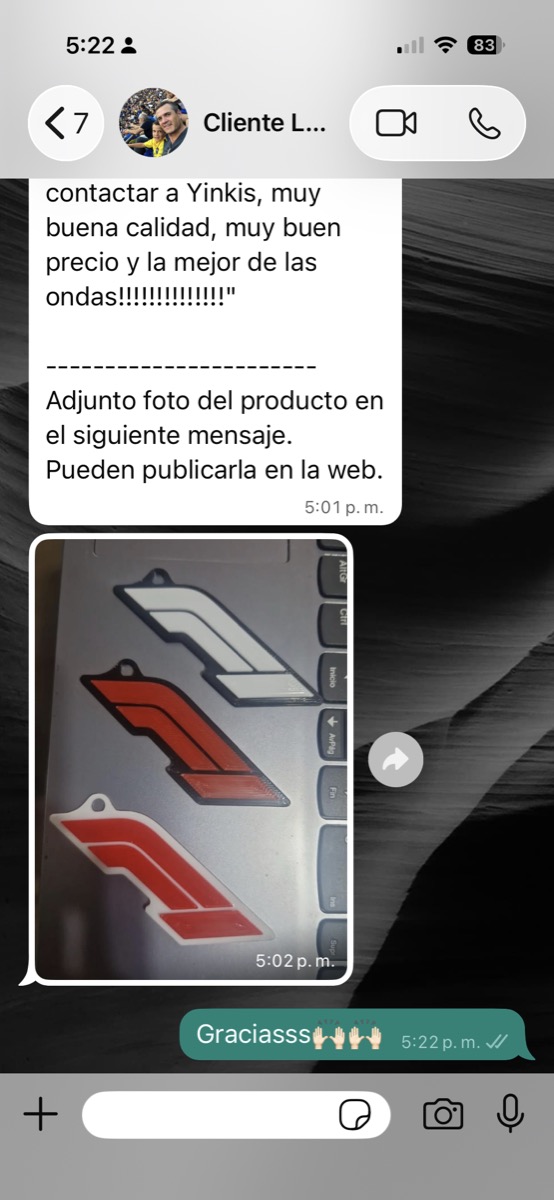 Llaveros 3D del logo de Fórmula 1 recibidos por Lisandro: uno blanco con detalle negro y dos rojos con detalle blanco